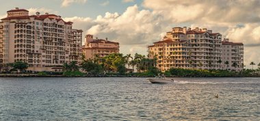 Marinaya yüzen bir tekne. Fisher Adası 'nda lüks bir yat teknesi. Yaz tatili. Fisher Adası konut binası ve lüks yat teknesi. Miami 'de Fisher Adası' na yat gezisi..