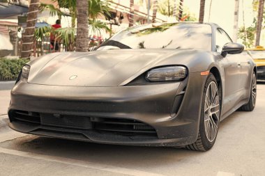 Miami, Florida, ABD - 20 Aralık 2024: Porsche Taycan 2023 elektrikli sedan. Elektrikli sedan araba Porsche Taycan. Siyah Porsche Taycan dışarıda park halinde. Porsche Taycan elektrikli sedan araba, köşe görüş..