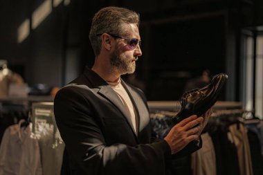 Klasik deri ayakkabı resmi görünümü. Resmi ayakkabı. Deri ayakkabılar. Ayakkabı mağazasındaki tezgahtar adam klasik ayakkabıları tutuyor. Ayakkabı mağazası. İş adamı dükkanda şık ayakkabılar seçer. Müşteri hizmetleri.