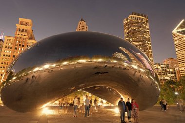 Chicago, Illinois, ABD - 22 Ekim 2024: Millennium Park ve ünlü Cloud Gate heykeli. Fasulye heykeli. Gökdelenli gece şehri manzarası. Chicago Milenyum Şehir Parkı. Bulut Kapısı.