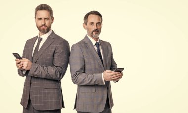 İş mesajlaşması. İnternet üzerinden iş mesajlaşması. Takım elbiseli iş adamları telefon kullanır. Mesajlaşan iki işadamı e-postaları kontrol ediyor. Telefondaki mesajları okuyan iş adamları beyazdan izole edilmiş. İleti çağrısı.