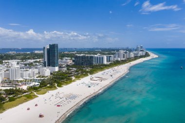 Turkuaz suları olan Miami plajı. Kumlu sahil şeridi ve dalgaların havadan görünüşü. Plajlı tropik Miami sahnesi