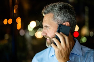 Telefon kullanan bir iş adamı. Erkek telefon konuşması. Akıllı telefonlu İspanyol bir iş adamı. İş iletişimi. Telefona cevap veren adam. Zengin işadamı açık havada konuşuyor, kopyalama alanı.