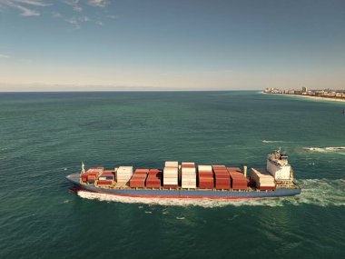 Kargo işi. Konteyner gemisi. Nakliye lojistiği. Ticari nakliye. Kargo gemisi denizde, insansız hava aracı manzaralı. Yük konteynırı kargo gemisine yüklendi. Deniz manzaralı kargo gemisi.