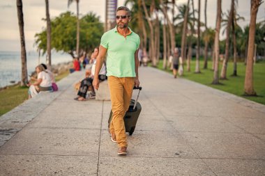 Yaz gezisi için seyahat valizleri. Yaz turu. Gezgin yaz tatili yapıyor. Şehir caddesinde yürüyen İspanyol turist. Bavullu turist. 40 'lı yılların yolcusu. Yaz tatilindeki turist.