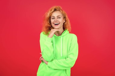 Kapüşonlu havalı bir kadın. Şık, sıradan tarzda şık bir kız. Kızıl saçlı manken kapüşonlu ve kot pantolon giyiyor. Kapüşonlu kadın koşucu. Pembe üzerine izole edilmiş kız kazağı. Runway modeli.