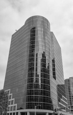 Gökdelen mimarisi. Camdan yapılmış bir gökdelen. Modern cam bina. Şehir merkezindeki gökdelen. Şehir hayatı. Şehir merkezinde gökdelenli. İş bölgesindeki ofis binası.