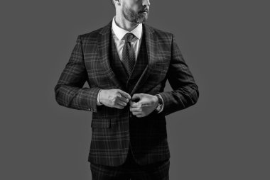 Zarif takım elbiseli bir iş adamı. Gri üzerine kravat takılmış resmi takım elbise ceketi. İş adamı ceketli adam. İş elbisesi. Resmi erkek giyimi. Formalite icabı giyinmiş bir adam. Kuyruklu Gardırop.