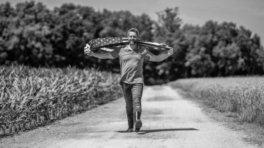 Amerikan bayrağı ve çiftçi adam. ABD bayrağı. Bağımsızlık Günü. Sahadaki adam. Ekin tarlasında Amerikan bayrağı taşıyan adam. Amerika 'nın Bağımsızlık Günü. 4 Temmuz. Amerikan İşçi Bayramı. Ulusal vatanseverlik.