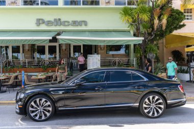 Miami, Florida, ABD - 27 Temmuz 2025 Bentley Flying Spur 2020 lüks sedan araba. Lüks araba Bentley Uçan Mahmuz. Araba Bentley Uçan Mahmuz dışarı park etmiş. Siyah araba, yan görüş..