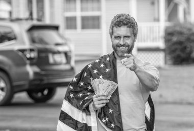 Amerikan vergi politikası. İspanyol adam ve Amerikan bayrağı. Amerika 'da vergi ödemek. Katma değer vergisi. Vergi sistemi. Vatansever adam. Amerikan bayrağı ve dolar parası olan adam. Enflasyon konsepti. İşaret parmağı.