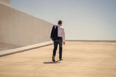 İşadamı tekrar dışarı çıkıyor. Takım elbiseli başarılı bir iş adamı. Hırslı bir iş adamı. İşadamı çekip gidiyor. Takım elbiseli zengin adam. Kentsel iş adamı yukarı çıkıyor. Şehir manzarası. Başarının yolu.