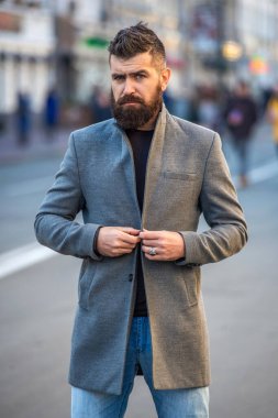 Sokakta sonbahar ceketli sakallı adam. İş adamının iş stili var. Şehir merkezindeki iş adamı. Şık bir işadamı karşıdan karşıya geçiyor. Şehir tarzı. Şehir sokakları ve şık adam.