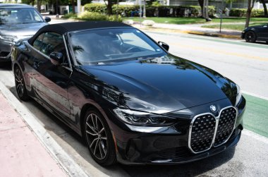 Miami, Florida, ABD - 27 Temmuz 2025: Üstü açılabilir BMW 4 Serisi 2022 araba. Üstü açık lüks BMW 4. Üstü açık BMW 4 arabası dışarıda park edilmiş. Siyah araba, köşe manzaralı..