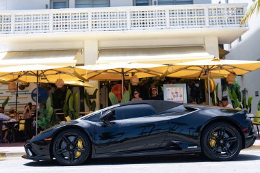 Miami, Florida, ABD - 27 Temmuz 2025: Lamborghini Huracan EVO Spyder 2020 üstü açık araba. Lüks Lamborghini Huracan EVO Spyder. Üstü açık araba Lamborghini. Siyah araba, yan görüş..