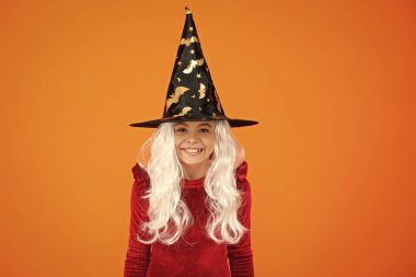 Şeker mi şaka mı? Cadılar Bayramı kostüm partisi kutlaması. Tüm Cadılar Bayramı cadıları. Yarasa şapkası. Cadılar Bayramı cadı kostümlü kız. Mutlu Cadılar Bayramı. Cadılar Bayramı kostümlü mutlu cadı kız turuncu üzerine izole.