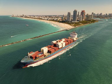 Yük konteynırı kargo gemisine yüklendi. Limandan ayrılan hava görüntülü kargo gemisi. Kargo işi. Konteyner gemisi. Nakliye lojistiği. Ticari nakliye. Kargo gemisi denizde, hava manzaralı..