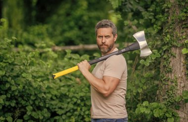 Oduncu baltası. Ağaç kesen baltalı adam. Erkeksi vahşi adam. Oduncu dışarıda kamp yapıyor. Acımasız oduncu. Vahşilik ve erkeklik. Baltalı İspanyol oduncu adam. Orman temizliği.