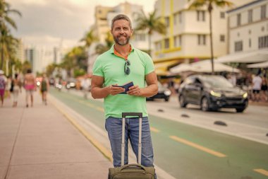 40 'lı yılların yolcusu. Yaz tatilindeki turist. Yaz gezisi için seyahat valizleri. Yaz turu. Gezgin yaz tatilinin tadını çıkar. Latin turist şehir caddesinde. Çantası ve pasaportu olan bir turist..