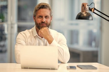 Serbest çalışan adam internette çalışıyor. Çevrimiçi çalışan serbest çalışan. Ofiste dizüstü bilgisayar kullanan bir adam. Serbest iş yapma. Erkek ofis yöneticisi. İş adamının internet işi var. İş adamı başarısı. Şirket ayarı.