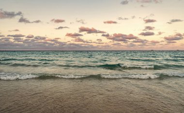 Deniz ufkuyla gökyüzü. Deniz doğarken sakin ufuk manzarası. Deniz manzarasında romantik yaz tatili gündoğumu. Deniz ufku manzarası. Yaz tatilinde bulutlu gökyüzü ve deniz manzarası. Deniz dalgaları.