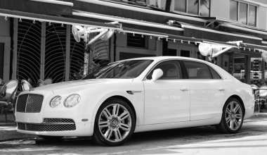 Miami, Florida, ABD - 17 Aralık 2024: 2016 Bentley Flying Spur Vur Sedan Car. Lüks araba beyaz Bentley Flying Spur V8 tipi. Bentley Uçan Mahmuz 'un arabası dışarıda park edilmiş. Bentley Uçan Mahmuz, yan görünüm.