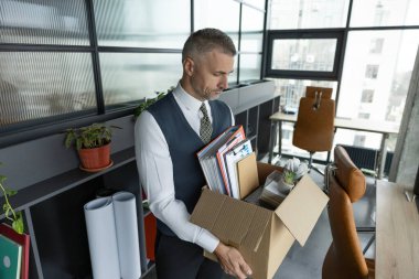 İstifa et ve istifa et. İş değişikliği ya da şirketten kovulma. İşini kaybediyor. İşsiz bir adam. Kariyer başarısızlığı. İş adamı ofis malzemeleriyle dolu kutuyu terk ediyor..