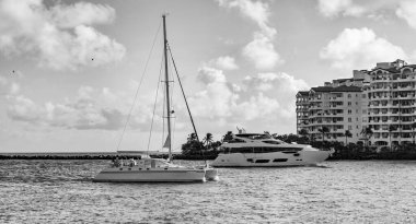 Marinaya yüzen bir tekne. Fisher Adası 'nda lüks bir yat teknesi. Yaz tatili. Fisher Adası konut binası ve lüks yat teknesi. Miami 'de Fisher Adası' na yat gezisi..
