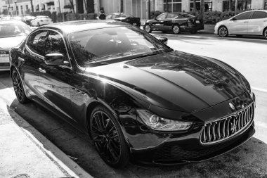 Miami, Florida, ABD - 17 Aralık 2024: Black 2014 Maserati Ghibli spor yara izi. Maserati Ghibli 'nin lüks spor arabası. Maserati Ghibli 'nin arabası dışarıda park edilmiş. Siyah Maserati Ghibli, köşe görünümü.