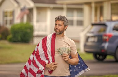 İspanyol adam ve Amerikan bayrağı. Amerika 'da vergi ödemek. Katma değer vergisi. Vergi sistemi. Vatansever adam. Amerikan bayrağı ve dolar parası olan adam. Enflasyon konsepti. Amerikan vergi politikası.