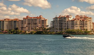 Fisher Adası Binası. Lüks motorlu tekne yatı. Yat marinaya gidiyor. Tekne ve yat gezisi. Lüks bir yaşam tarzı. Fisher Adası 'nda lüks bir binada yat. Yaz tatili. Romantik gün batımı.