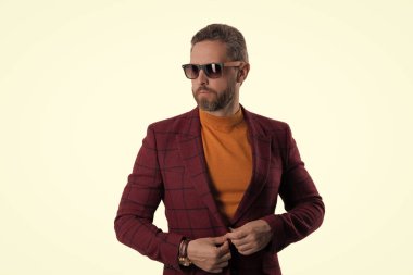 Beyaz tenli şık bir adam. Yakışıklı İspanyol adam modayı takip ediyor. Erkekler için moda. Ceket ve güneş gözlüğü takan kendinden emin bir iş adamı. Erkek modası. Terzi karmaşıklığı.