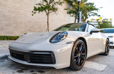 Miami, Florida, ABD - 27 Temmuz 2025: lüks araba Porsche 911. Porsche 911 'i dışarıda park etmiş. Beyaz üstü açık araba, köşe manzaralı. Porsche 911 992 nesil 2020 üstü açık coupe araba..