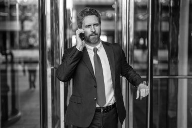 İş adamının telefonu var. Ofiste iş görüşmesi. İş görüşmesi çağrısı. Patrona telefon var. İletişim ve müzakere. İş adamı dışarıda telefonla konuşuyor. Şirket kültürü.