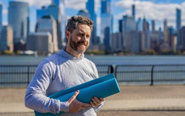 Yoga koçu. Sporcu adam antrenmana hazır. Sağlıklı bir yaşam tarzı. Spor ve spor. Yoga paspas eğitimi. New York 'ta sporcu. Manhattan 'da spor kıyafetli bir adam. Vücuduna uygun. Egzersiz paspası.