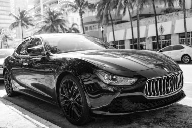 Miami, Florida, ABD - 17 Aralık 2024: Black 2014 Maserati Ghibli spor yara izi. Maserati Ghibli 'nin lüks spor arabası. Maserati Ghibli 'nin arabası dışarıda park edilmiş. Siyah Maserati Ghibli, köşe görünümü.