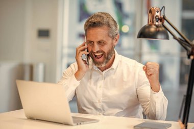 İş başarısı. Ofis müdürü dizüstü bilgisayar ve telefon kullanıyor. Çevik iş. Profesyonel iş adamının internet bağlantısı var. İş görüşmesi. Olgun iş adamı çevrimiçi çalışıyor. Haberler iyi..