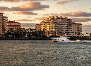 Marinaya yüzen bir tekne. Fisher Adası 'nda lüks bir yat teknesi. Yaz tatili. Fisher Adası konut binası ve lüks yat teknesi. Miami Fisher Adası Panorama Manzarası.