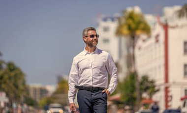 Dışarıda başarılı bir iş adamı. İşadamı tarzı bir portre. Başarılı bir iş lideri. İş adamının iş başarısı. İş adamı liderliği. Liderlik rolü. Güneş gözlüklü zengin adam..