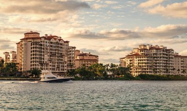Marinaya yüzen bir tekne. Fisher Adası 'nda lüks bir yat teknesi. Yaz tatili. Fisher Adası konut binası ve lüks yat teknesi. Miami Fisher Adası Panorama Manzarası.