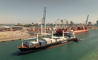Miami, Florida, ABD - 20 Mart 2025: Kargo gemisi. Miami liman lojistiği. Monrovia konteynırı gemisi. Kargo Seaboard Explorer konteynır gemisi, hava manzaralı. Yük konteynırı kargo gemisi ve römorkör..