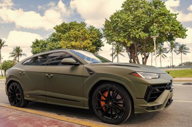 Miami, Florida, ABD - 08 Aralık 2024: Luxur yeşil renkli Lamborghini Urus S tipi spor araba. Lamborghini Urus 'un arabası dışarıda park halinde. Lamborghini Urus, köşe manzaralı. 2024 Lamborghini Urus S SUV arabası.