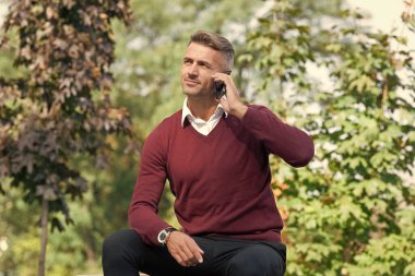 Telefonda ilham verici bir adam konuşması. Telefon var. Mobil bağlantı. Akıllı telefonlu bir iş adamı. İş iletişimi. Modern iletişim. Adam dışarıda telefonla konuşuyor. Olgun adam çağırıyor.