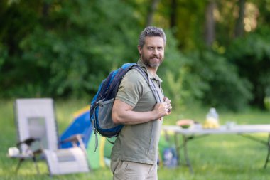 Sırt çantalı bir gezgin. Yürüyüş macerası. Seyahat yaşam tarzı. Kırsalda yürüyüş yapan bir adam. Ormandaki İspanyol adam. Ormanda yürüyüş yapan sırt çantalı bir yürüyüşçü. Erkek yürüyüşçü ormanda piknik yapar..