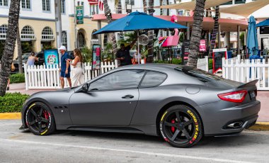 Miami, Florida, ABD - 27 Temmuz 2025: lüks Turismo arabası Maserati. Araba Coupe Maserati dışarıda park etmiş. Siyah mat araba, yan görüş. Maserati Gran Turismo 2015 coupe car.