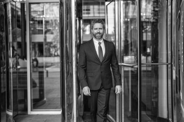 Takım elbiseli adam ofise yürür. Ofis binasındaki İspanyol işadamı. Dışarıda başarılı bir iş adamı. Şehir caddesinde yürüyen bir adam. Takım elbiseli bir iş adamı. İş adamının iş başarısı. Buluşma ortağı.