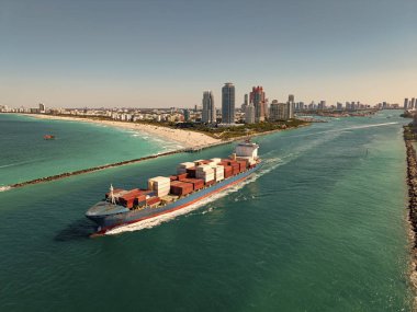 Denize bakan kargo gemisi. Kargo işi. Konteyner gemisi. Nakliye lojistiği. Ticari nakliye. Kargo gemisi denizde, hava manzaralı. Yük konteynırı kargo gemisine yüklendi.