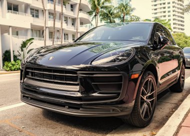Miami, Florida, ABD - 16 Kasım 2024: lüks Porsche Macan. Araba siyah renkli Porsche Macan dışarıda park etmiş. Porsche Macan, köşe manzaralı. 2024 Porsche Macan geçidi siyah araba.