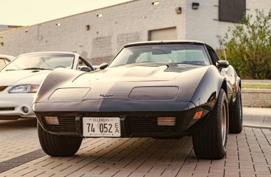 Park Ridge, Illinois, ABD - 18 Ağustos 2024: Corvette c3 stingray. Otomobil fuarında park edilmiş siyah bir araba. Corvette c3 vatozlu araba. Siyah Corvette C3 vatozlu araba