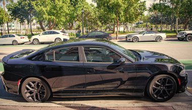 Miami, Florida, ABD - 17 Aralık 2024: Siyah 2023 Dodge Charger GT arabası. Dodge Charger GT tipi lüks bir araba. Dodge Charger GT 'nin arabası, dışarıda park edilmiş. Dodge Charger GT, yan görünüm.